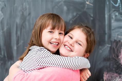 Premium Photo Portrait Of Two Happy Cute Little Girls Hugging Each