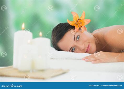 Beautiful Brunette Relaxing On Massage Table Smiling At Camera Stock
