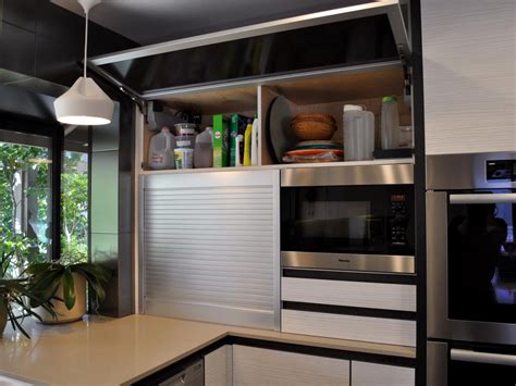 Since you won't be pulling the microwave out to use it, make sure you position the appliance garage in a convenient spot. Flip-Up Kitchen Storage Cabinet and Appliance Garage | HGTV