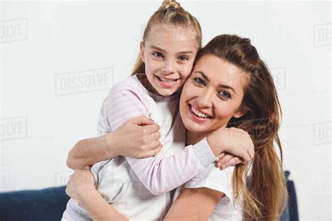 Mom And Daughter Embracing And Smiling At Home Stock Photo Dissolve