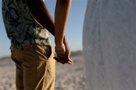 mixed race couple holding hands and smiling into the camera on a sunny day stock image image