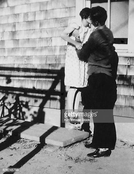 A Young Couple Engage In Some Serious Kissing While Outside Photo D