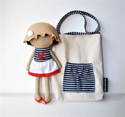A Stuffed Doll Next To A Handbag On A White Surface With A Bag In The