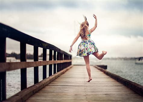 Young Girl Dancing On A Dock Above A River On A Cloudy Day By Angela