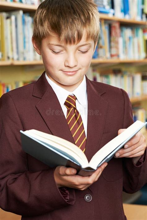 Boy Wearing School Uniform Reading Book In Library Stock Image Image