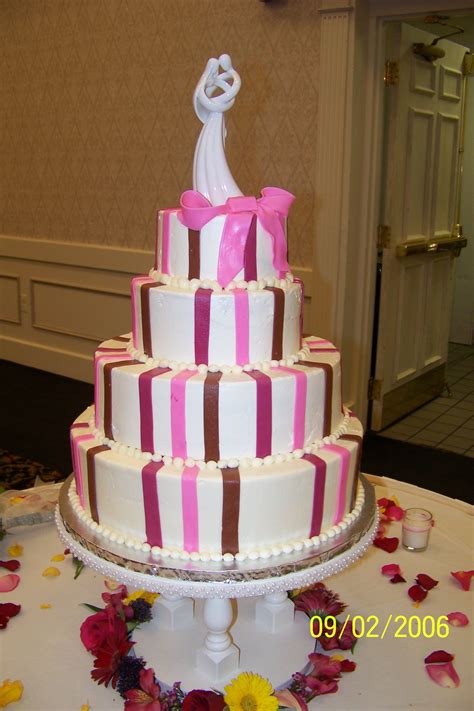 Pink Vertical Stripes Wedding Cake With A Pink Fondant Bow White Ceramic Embrace Couple Topper