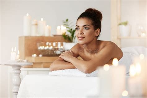 Tender African Girl Smiling Looking Into Distance Relaxing In Spa Salon