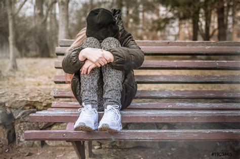 Sad Depressed Young Girl Sitting On A Bench In A Stock Photo 1903465