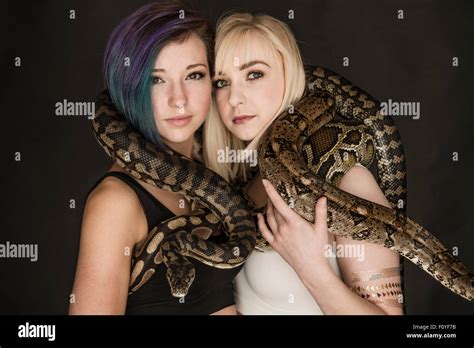 zwei junge frauen mädchen frauen posiert mit schlangen umschlungen um ihre körper uk
