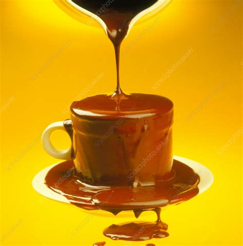 molten chocolate being poured into a cup stock image h110 0511 science photo library