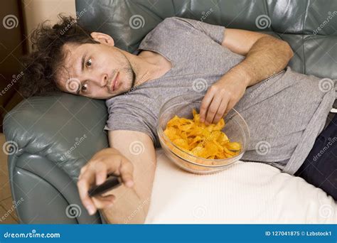 Man With Remote And Chips Watching TV At Home Stock Image Image Of