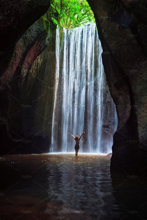 Woman Stand Under Cave Waterfall Featuring Bali Travel And Indonesia