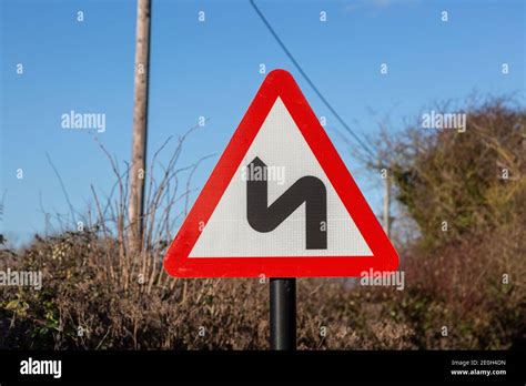 Red Triangle Road Sign Warning Of Sharp Corners Ahead Uk Stock Photo