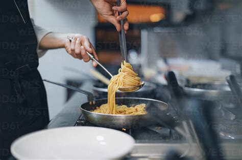 Chef Preparing A Pasta Dish In Traditional Italian Restaurant Kitchen