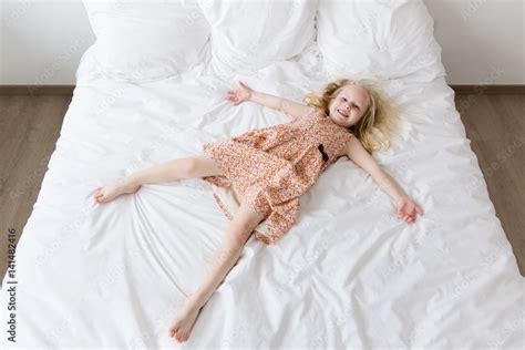 Overhead View Of A Smiling Babe Girl Lying On A White Bed Stock Photo Adobe Stock