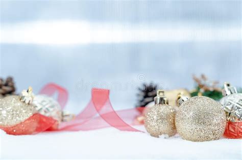 Golden Christmas Balls With Ribbon On Snow Winter Holidays Concept