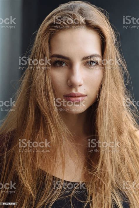 Portrait Of Beautiful Ginger Hair Girl In A Coat With Red Lips Posing By The Street In A City