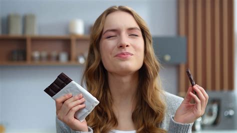 Portrait Of Young Woman Eating Chocolate At Home Kitchen Beautiful