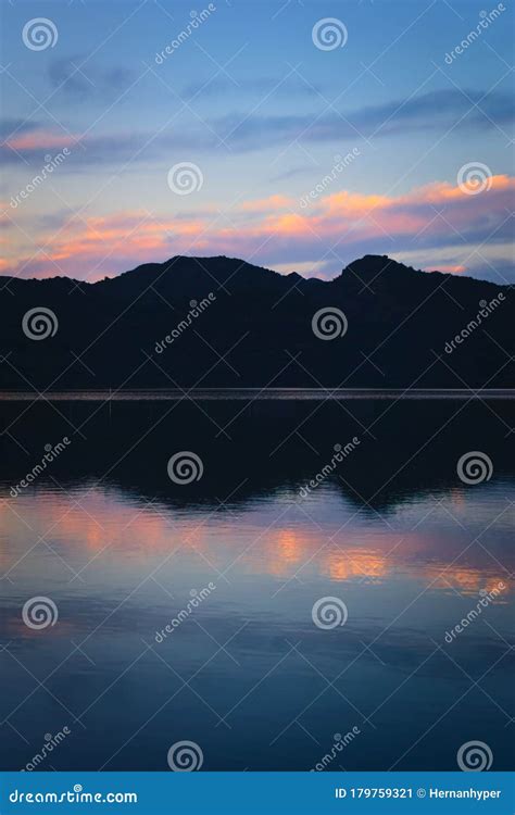 Blue Twilight Sky And Dark Mountains Reflected On The Calm Waters Of A
