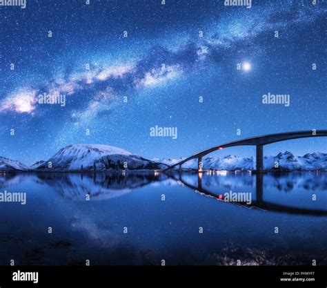 Bridge And Starry Sky With Milky Way Over Snow Covered Mountains