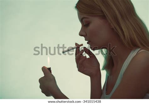 Pretty Girl Smoking Cigarette Using Lighter Stock Photo