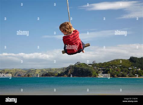 Boy On Rope Swing Oakura Bay Northland North Island New Zealand