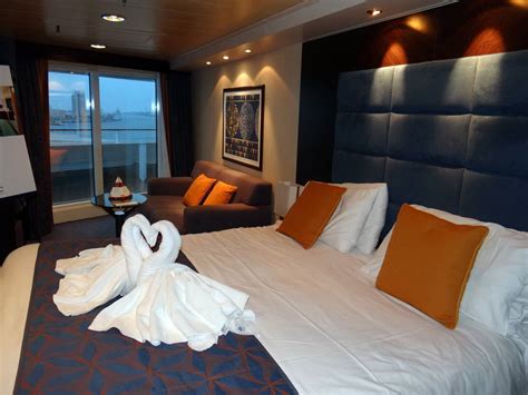 The layout includes ample storage and a pleasant color scheme featuring earth tones accompanied by blue, gold, and burgundy accents. MSC Divina - Cabins and Suites