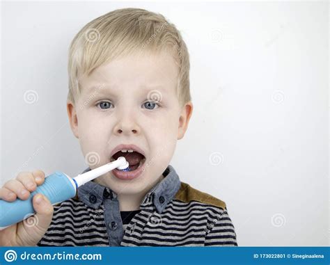 4 Годовалых кисти ребенка зубы щеткой с электрической Мальчик на белом