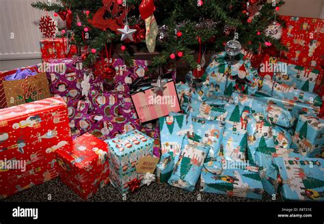 A Pile Of Neatly Wrapped Christmas Presents Beneath A Christmas Tree