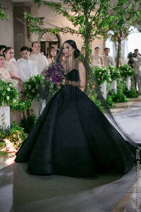 A Woman In A Black Wedding Dress Walking Down The Aisle