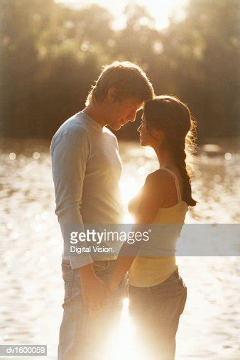 Adoring Couple Gazing At Each Other By A Lake In A Park Photo Getty