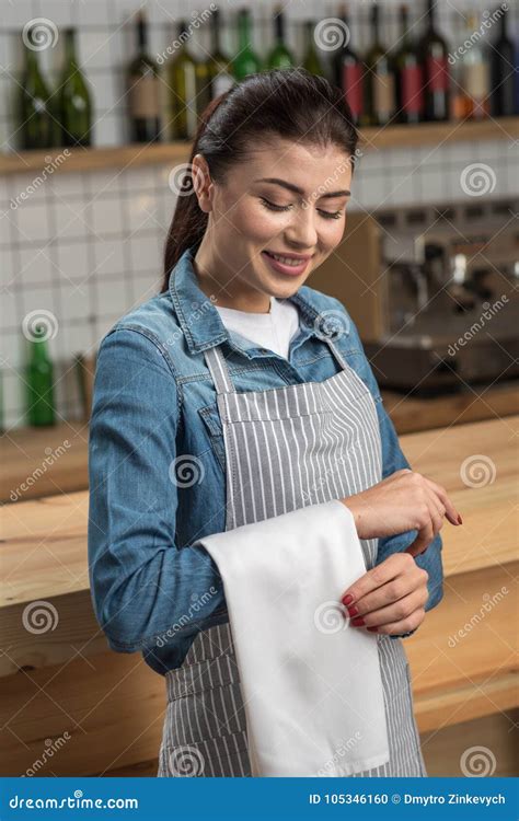 Cute Professional Waitress Looking At The Towel On Her Arm And Smiling