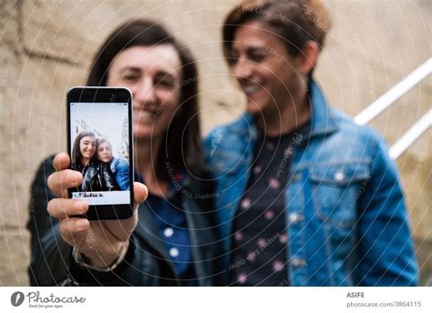 happy middle aged lesbian couple showing a selfie in the smart phone a royalty free stock