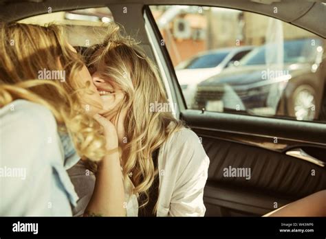 Young Lesbians Couple Kissing Before Vacation Trip On The Car In Sunny