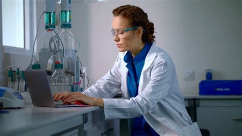 Female Scientist Working In Laboratory Lab Worker Typing Test Report On Computer Scientist