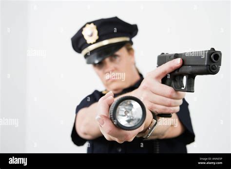 Police Woman Pointing Handgun And Holding Flashlight Stock Photo