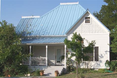 Orange roof tile pattern over blue and cloudy spring sky day and green tree in the background. This frame house with a blue metal roof was built for H. L ...