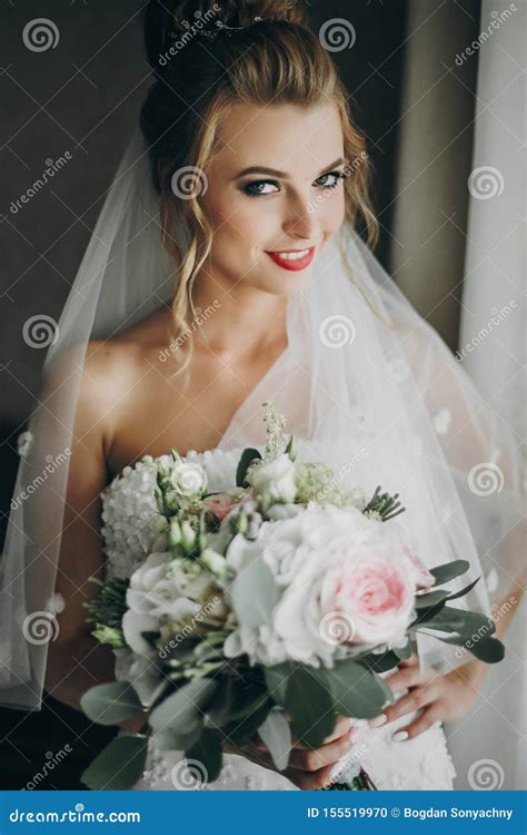 Stylish Bride Holding Modern Wedding Bouquet And Posing In Soft Light