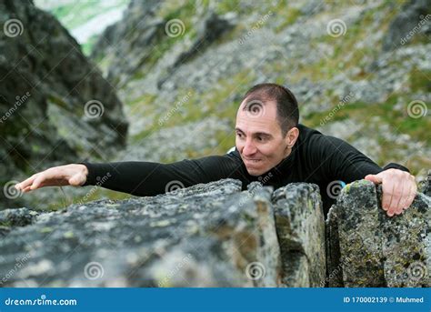 Young Man Makes Hard Climbing A Steep Rock Without A Rope Rock Climb