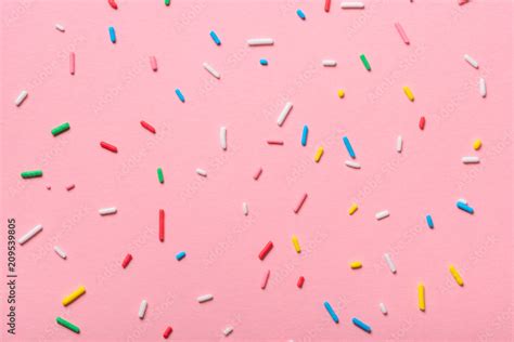 Colorful Sprinkles Over Pink Background Decoration For Cake And Bakery