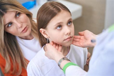 Pediatrician Touching Little Girl Neck Examining Lymph Nodes Stock