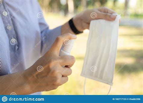 Hand Of Woman Is Spraying Alcohol On Medical Mask Clean Washing For