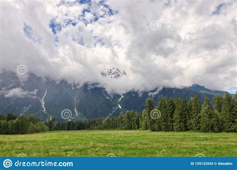 Cumulus Clouds Over Picturesque Mountain Ranges With Coniferous Forest
