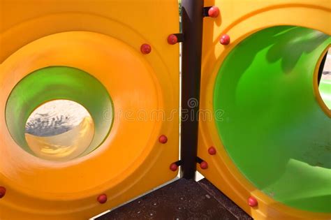 Green And Yellow In Tunnel Tube Of Slide In Playground Stock Photo