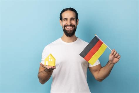 Premium Photo Man With Beard Holding German Flag And Paper House