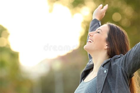 Happy Lady Breathing Fresh Air Raising Arms In A Park Stock Image
