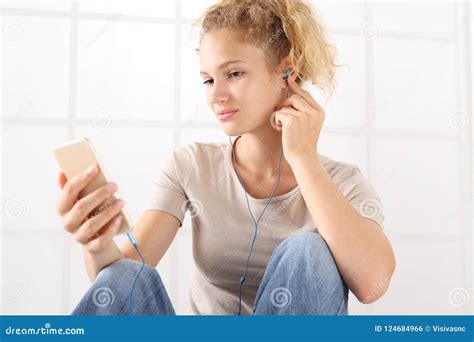 Portrait Young Woman With Smartphone And Earphones Look At The Stock