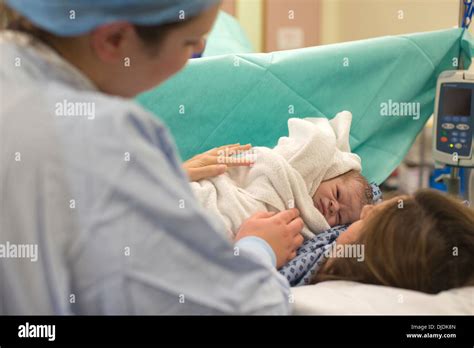 Newborn Baby Boy Being Checked By Nurses In Hospital Maternity Stock