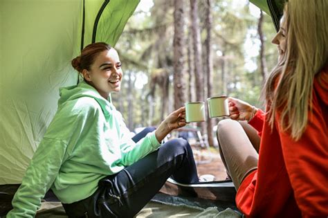 Smiling Lesbian Couple Having Coffee Celebratory Toast In Tent During