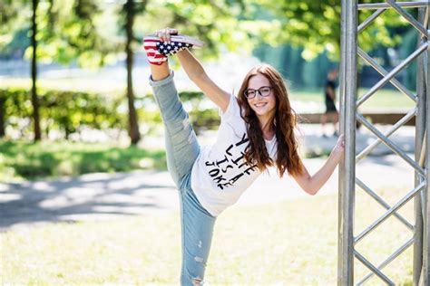 premium photo portrait of a beautiful flexible woman doing split in the park on a sunny day